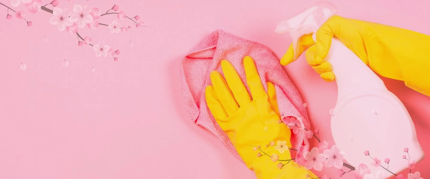 Yellow cleaning gloves and a pink cloth beside a spray bottle.